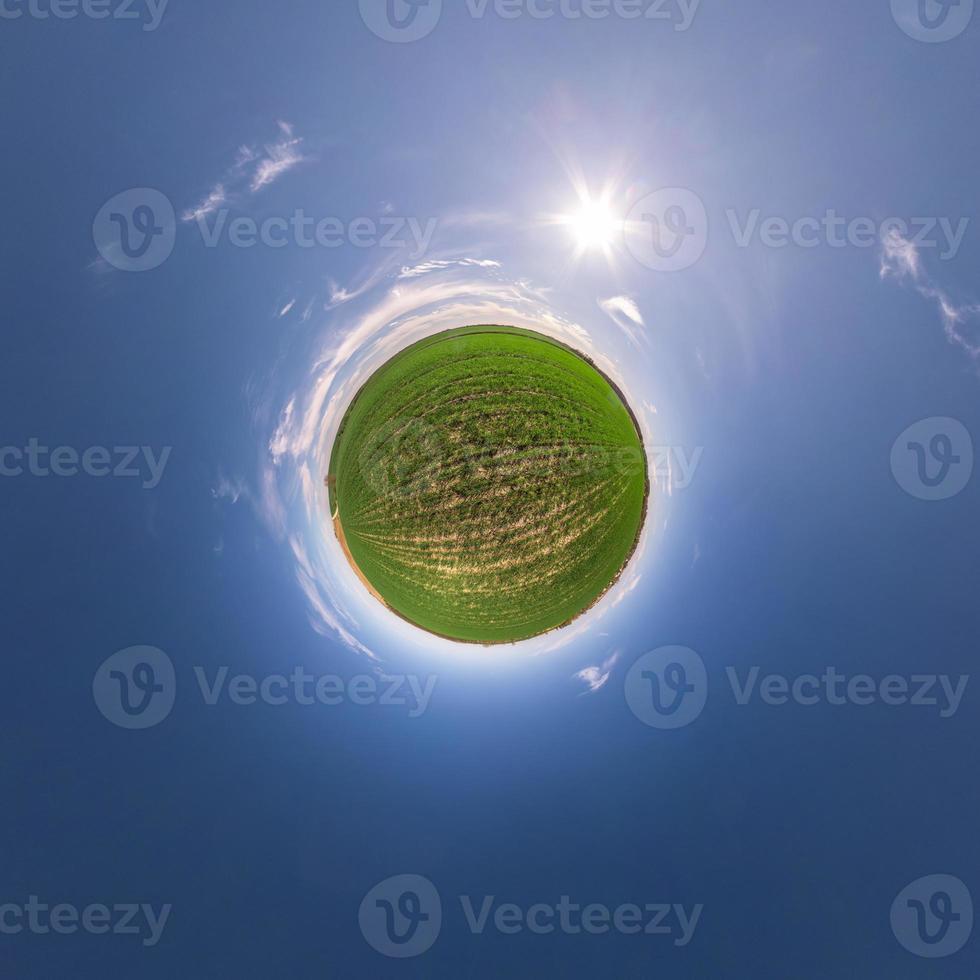 Little planet transformation of spherical panorama 360 degrees. Spherical abstract aerial view in field with awesome beautiful clouds. Curvature of space. photo