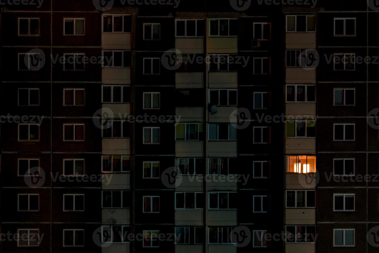 light in a single window. Flat night panorama of multicolor light in windows of multistory buildings. life in big city photo