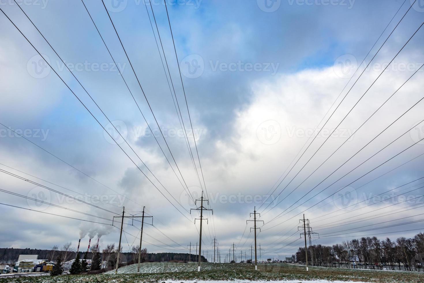 Silhouette of the high voltage electric pylon towers on the background of beautiful clouds photo