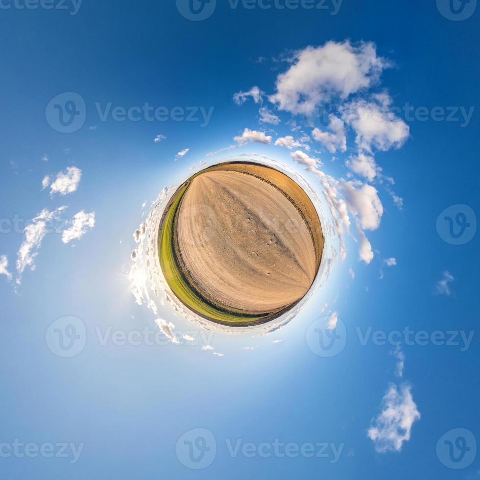 Little planet transformation of spherical panorama 360 degrees. Spherical abstract aerial view in field with awesome beautiful clouds. Curvature of space. photo