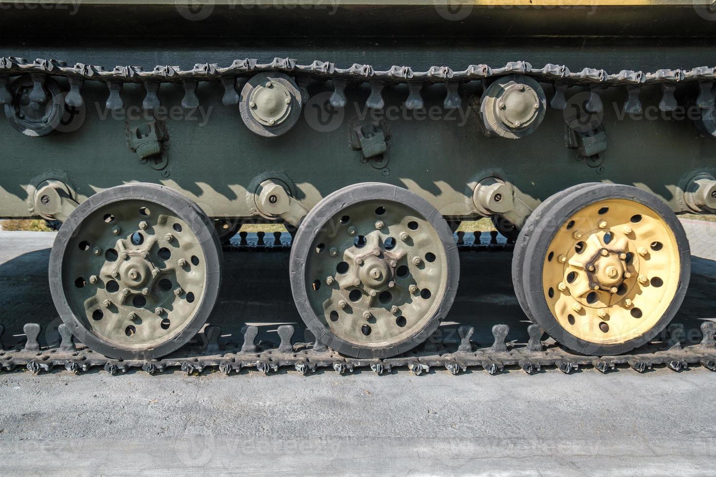 tracks and wheels of tank, armored vehicles on the street in green khaki color photo