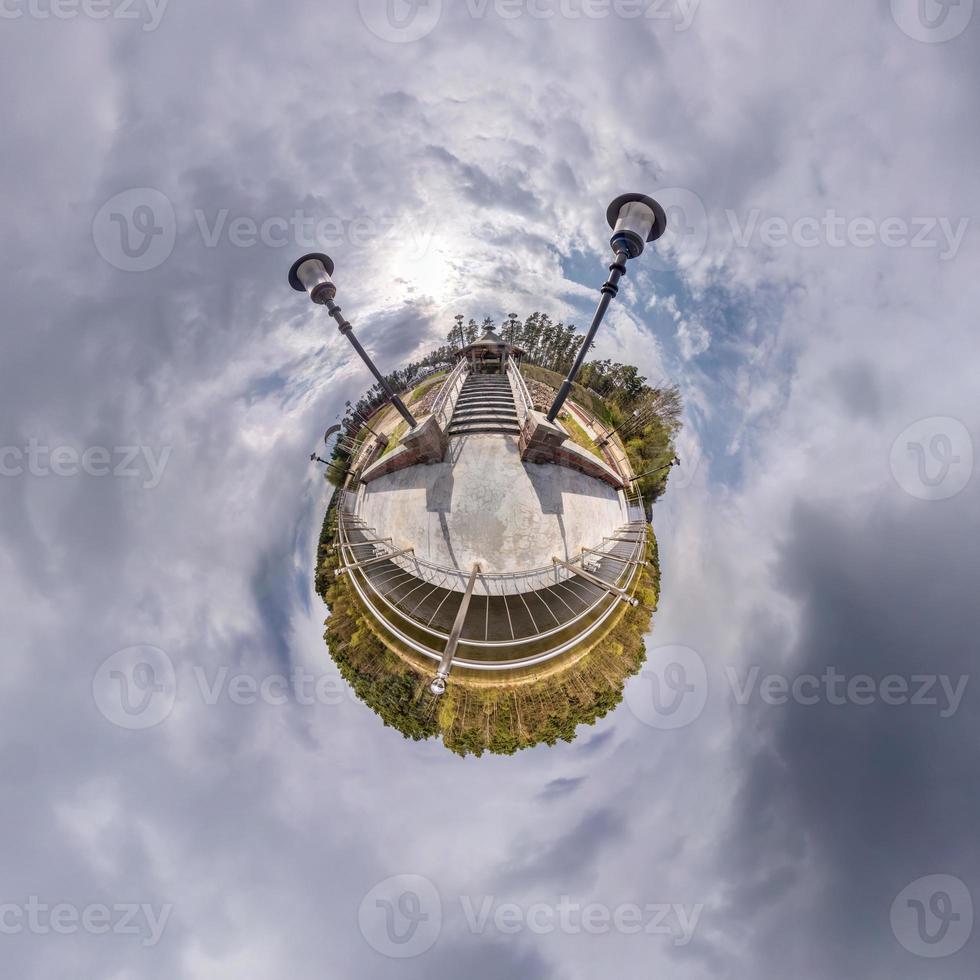 Little planet transformation of spherical panorama 360 degrees. Spherical abstract aerial view in field with awesome beautiful clouds. Curvature of space. photo