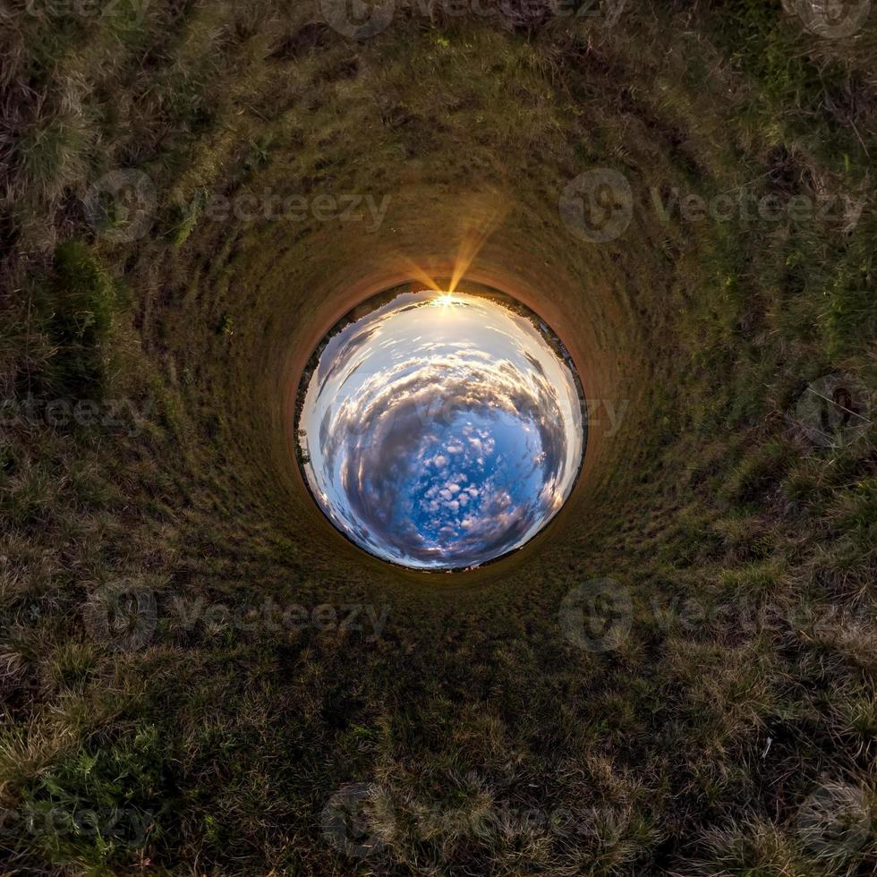 Inversion of little planet transformation of spherical panorama 360 degrees. Spherical abstract aerial view in field with awesome beautiful clouds. Curvature of space. photo