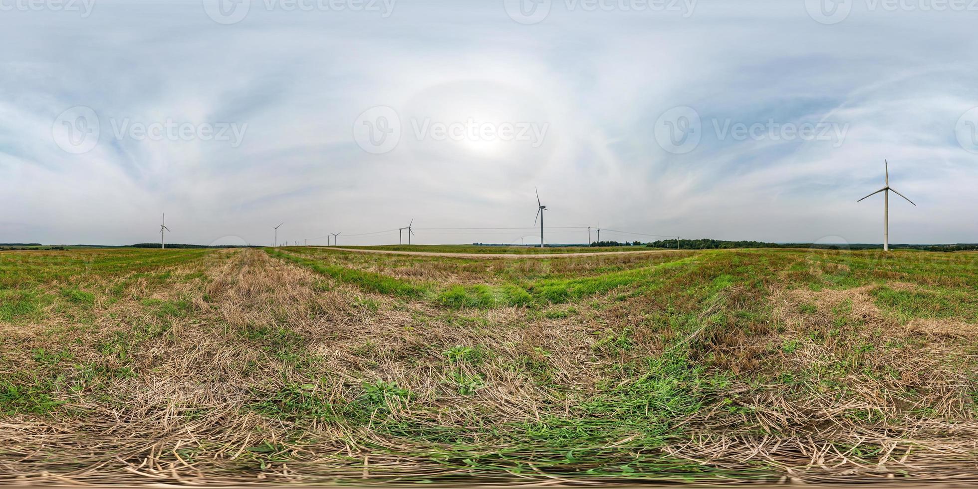 full seamless spherical hdri panorama 360 degrees angle view near huge windmill propeller with halo in sky in equirectangular projection, VR AR virtual reality content. Wind power generation. photo
