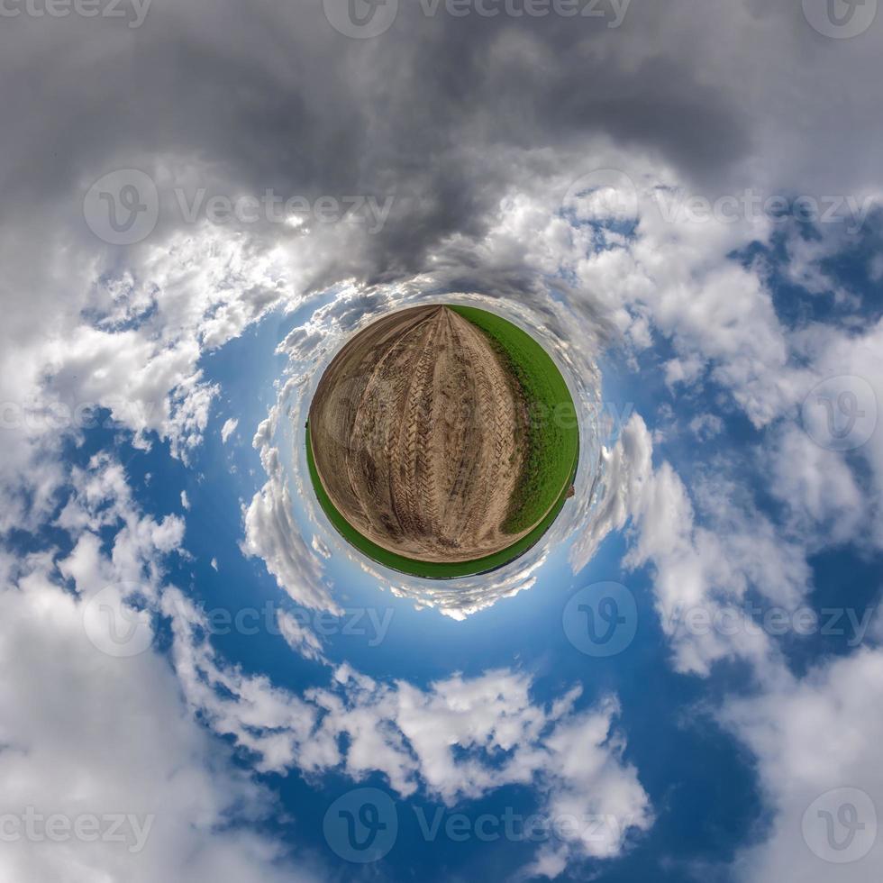 tiny planet in blue sky with beautiful clouds. Transformation of spherical panorama 360 degrees. Spherical abstract aerial view. Curvature of space. photo