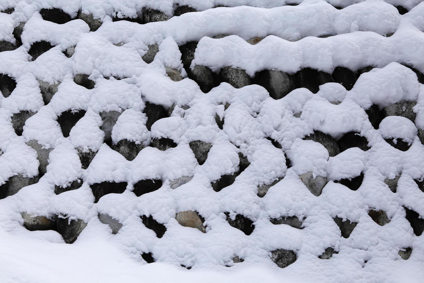 muro de piedra cubierto de nieve i foto