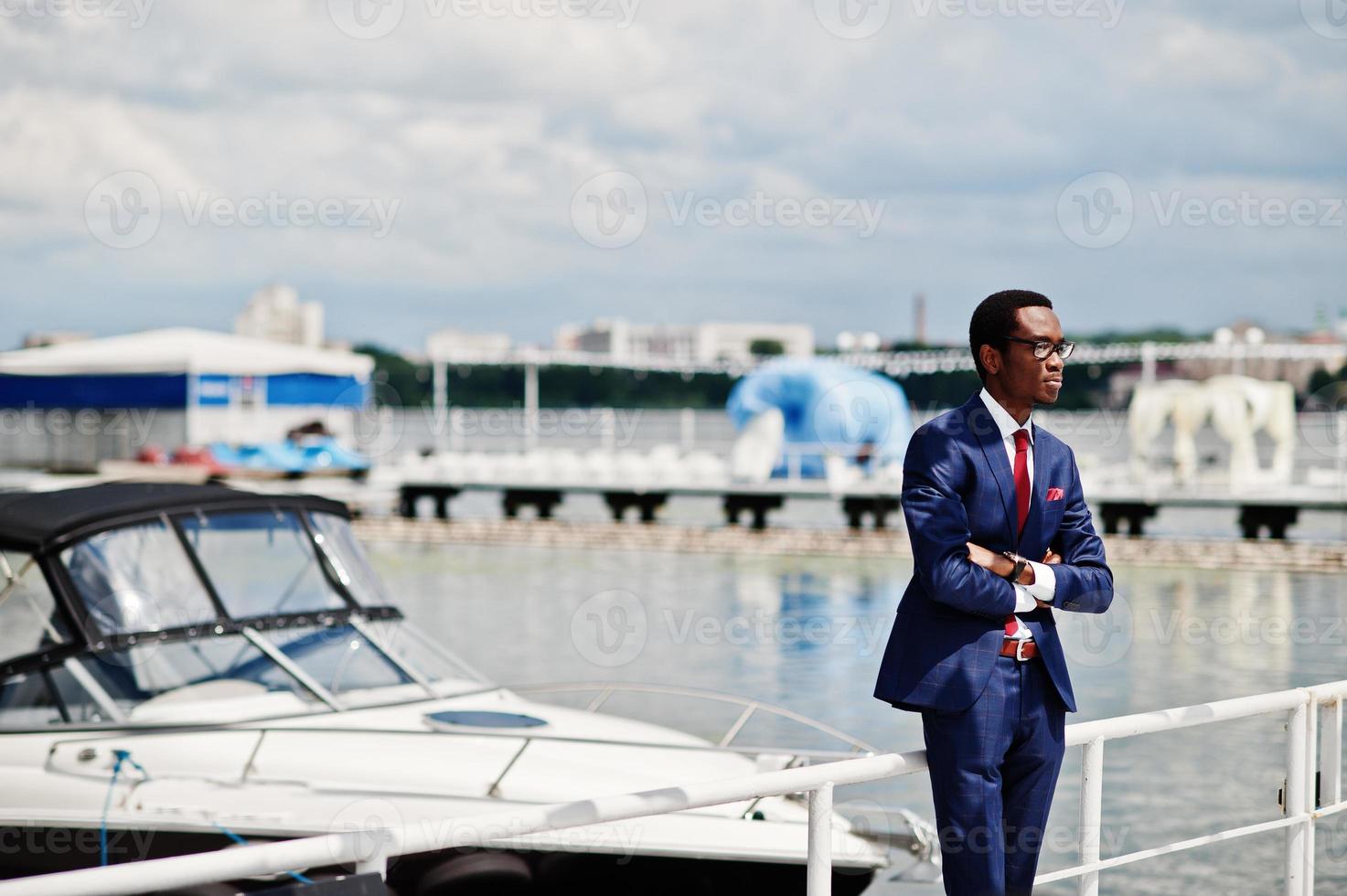 African american happy successful man at suit against yacht. Rich black business man. photo