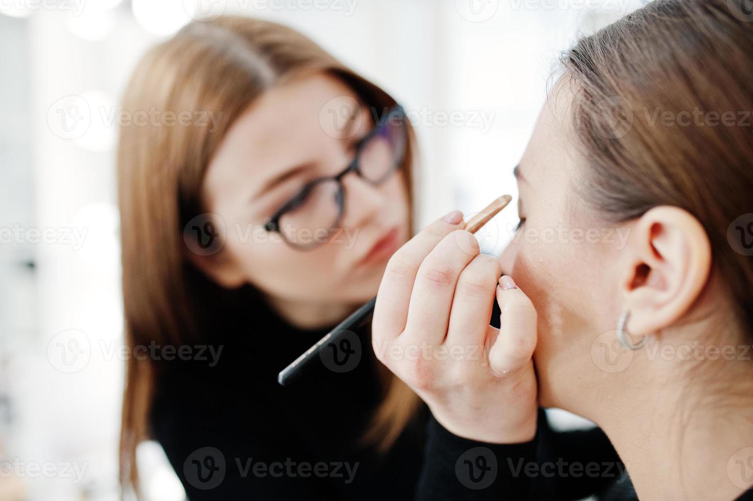 Make up artist work in her beauty visage studio salon. Woman applying