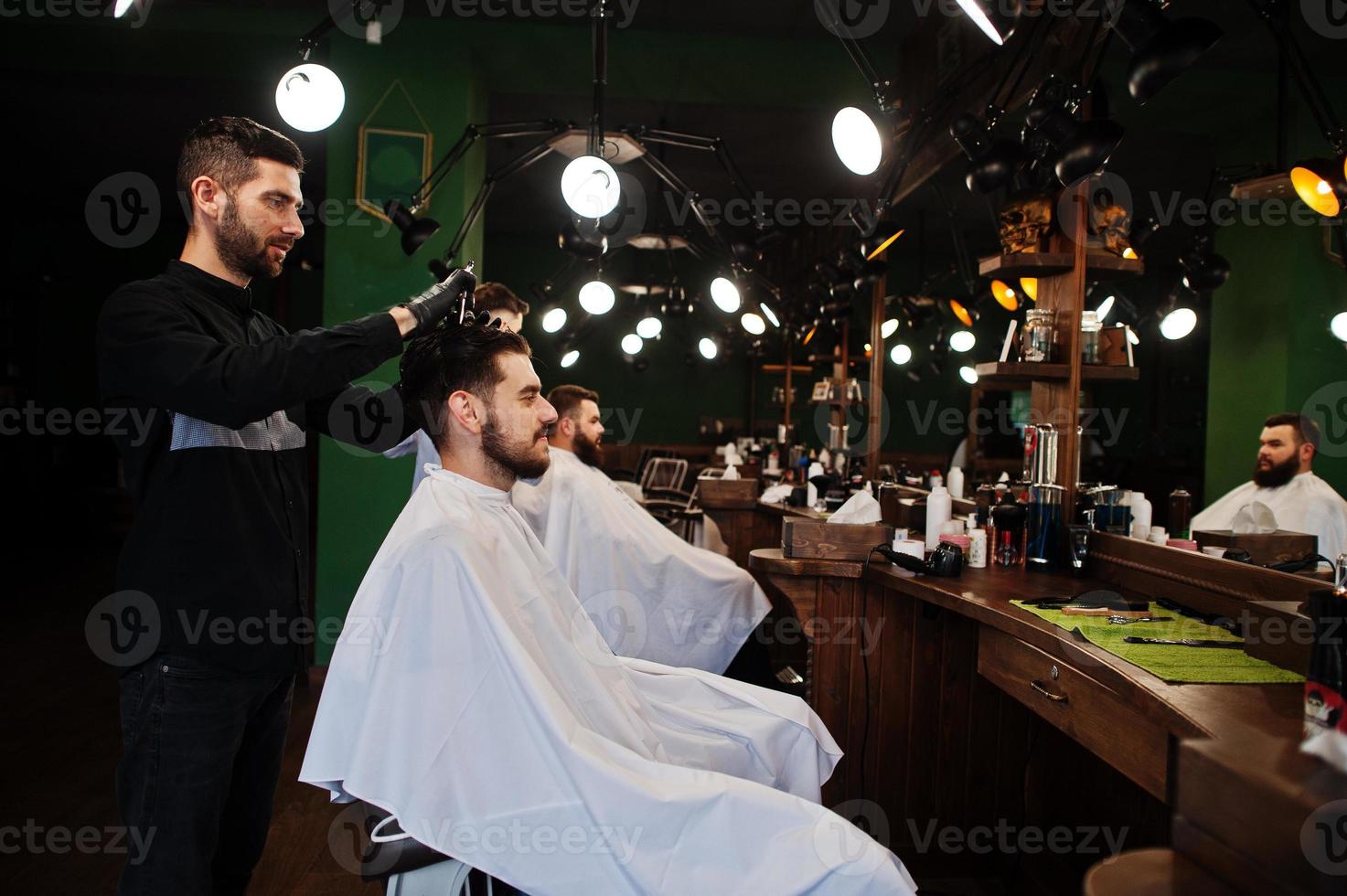 apuesto hombre barbudo en la barbería, peluquero en el trabajo. foto