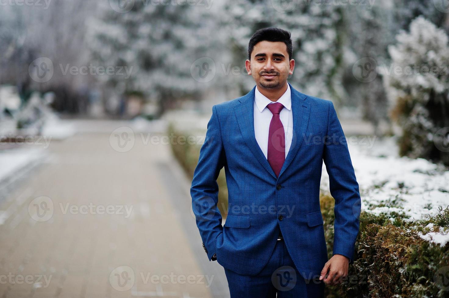 elegante modelo de hombre de moda indio en traje posado en el día de invierno. foto