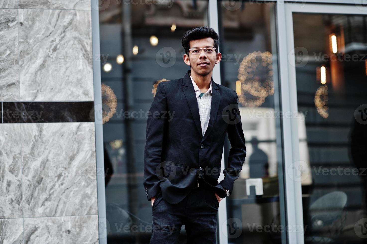 joven indio con traje y gafas posó al aire libre. foto