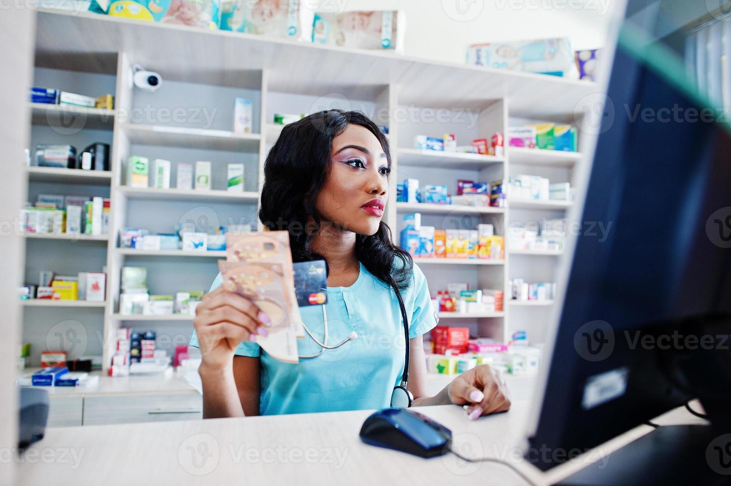 African american pharmacist working in drugstore at hospital pharmacy. African healthcare. Cashier holding money euros. photo