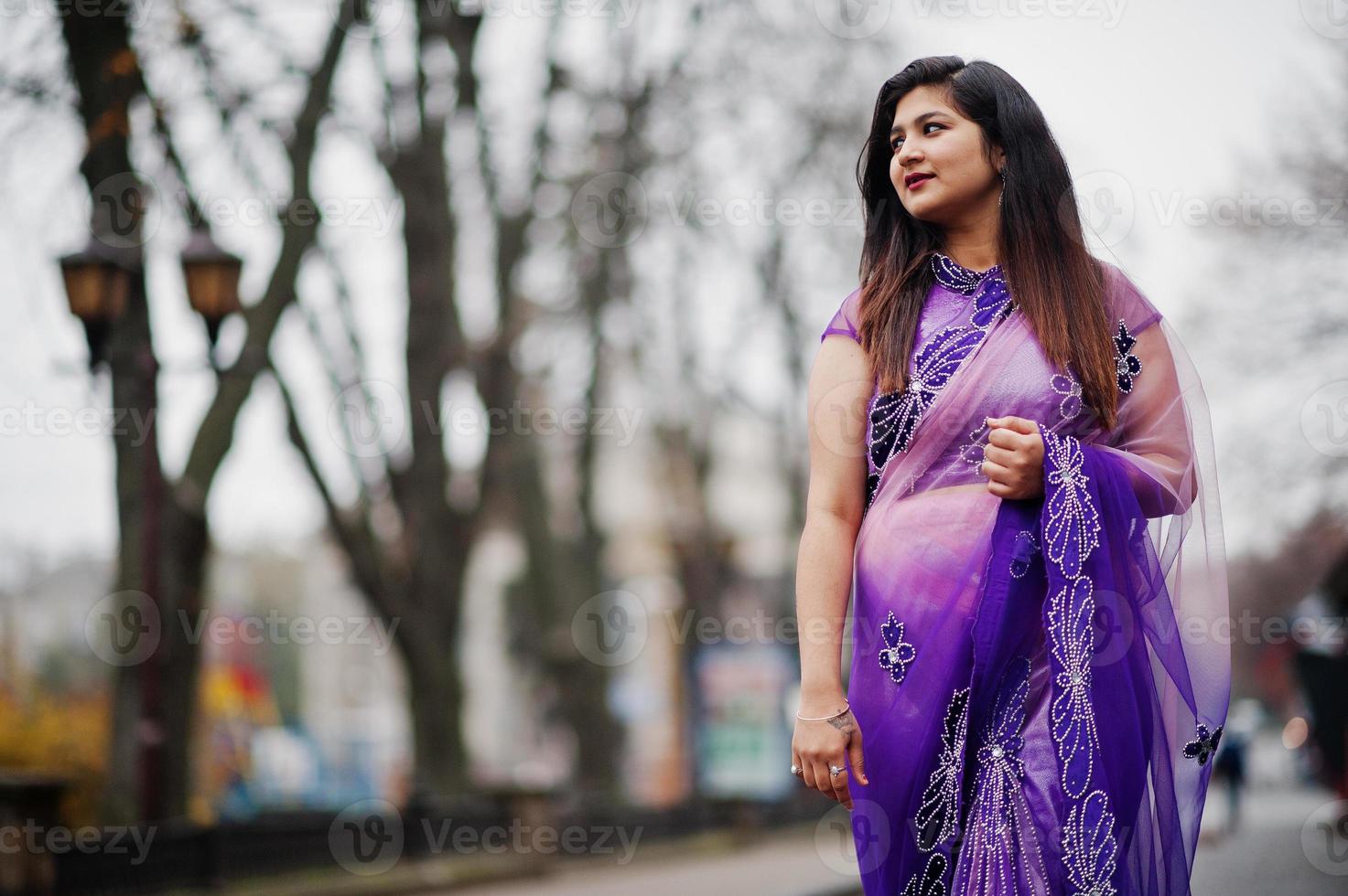 Indian hindu girl at traditional violet saree posed at street. photo