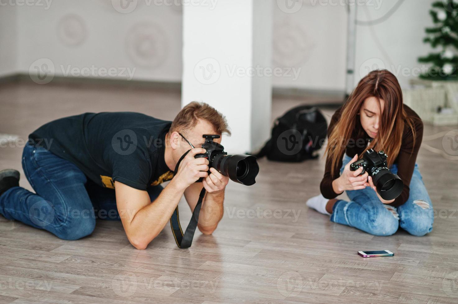 The team of two photographers shooting on studio at knees. Professional photographer on work. Master class. photo