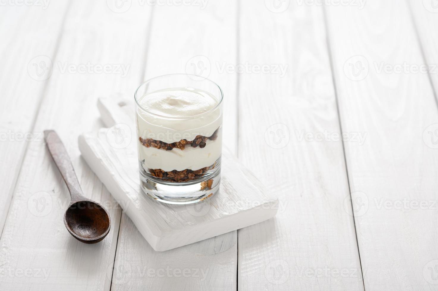 Greek yogurt with granola in glass jar. Parfait photo