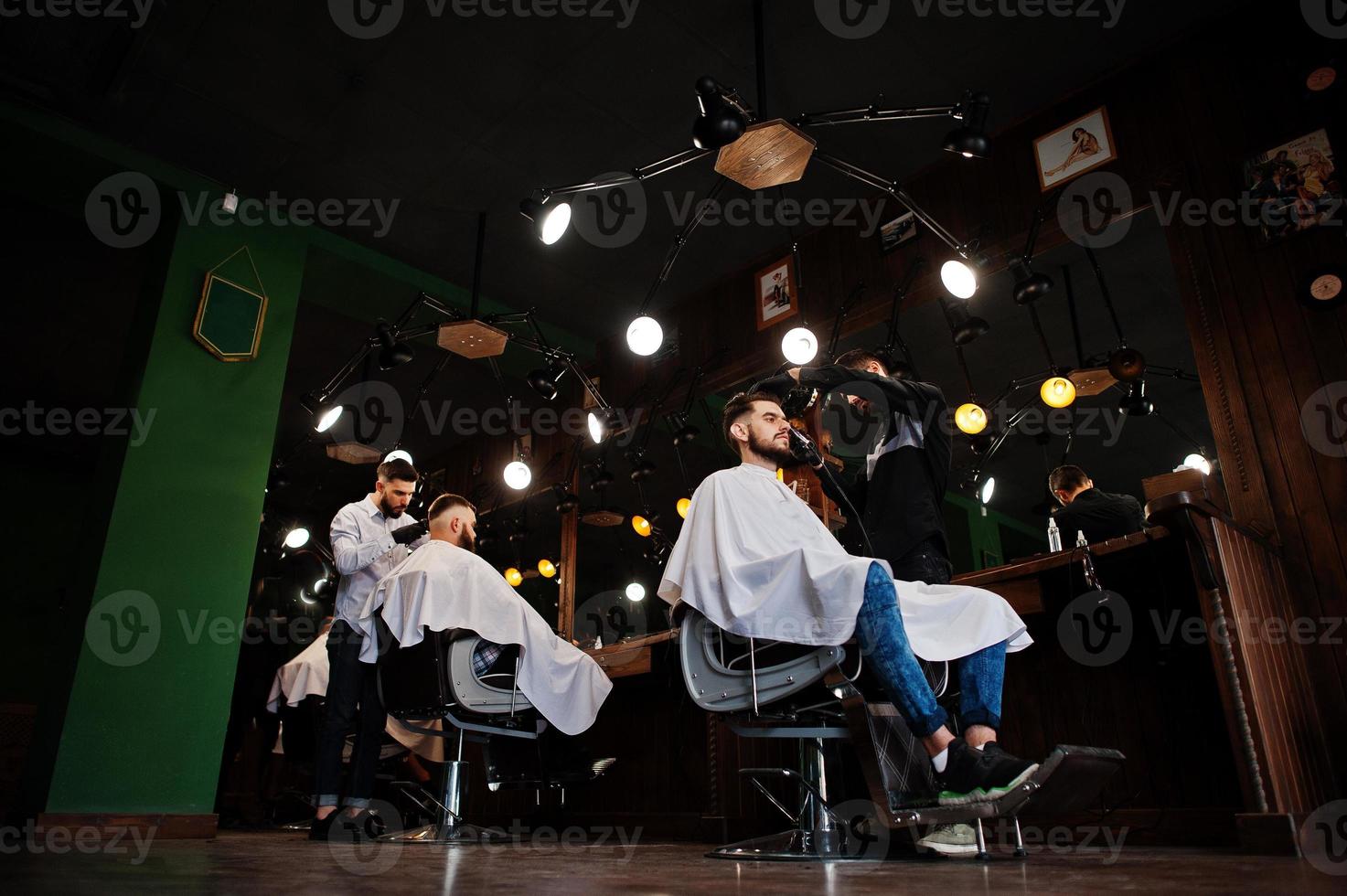 apuesto hombre barbudo en la barbería, peluquero en el trabajo. foto