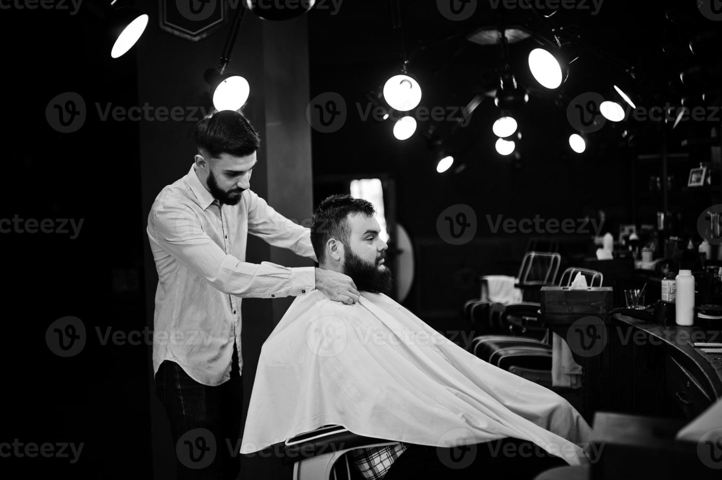 Handsome bearded man at the barbershop, barber at work. photo