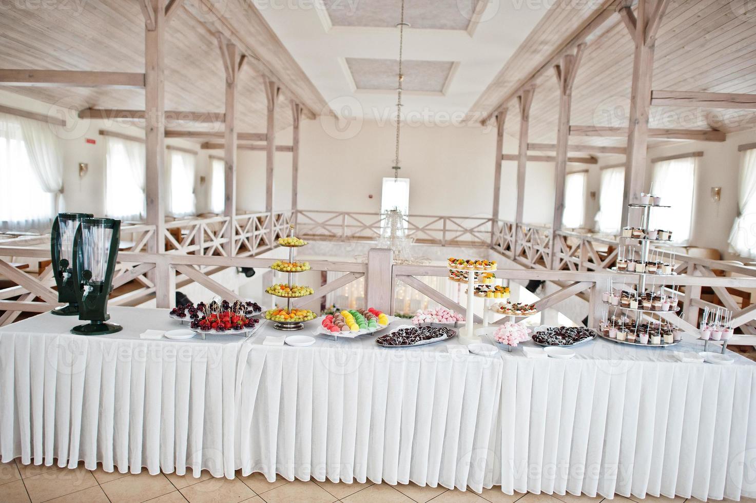 Beautiful wedding candy bar with sweets, fruits and food. Wedding banquet table photo