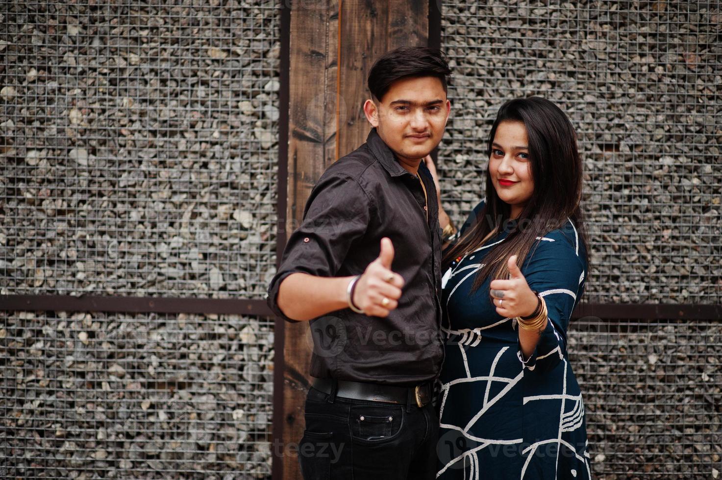 Love story of indian couple posed outdoor, shows thumb up. photo