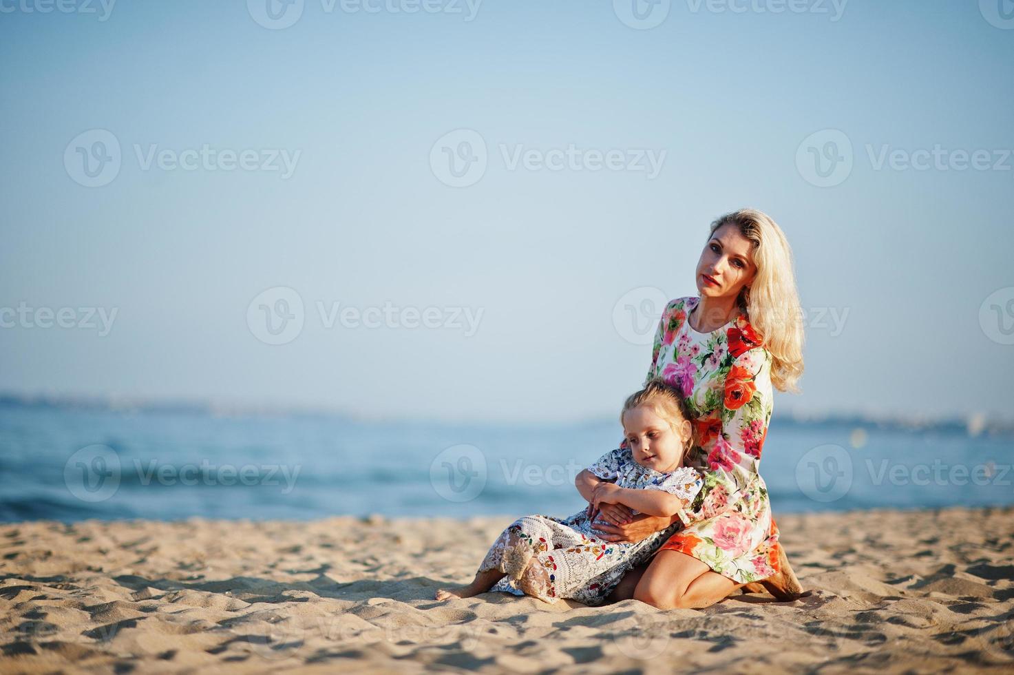 madre e hija hermosa divirtiéndose en la playa. retrato de mujer feliz con linda niña de vacaciones. foto