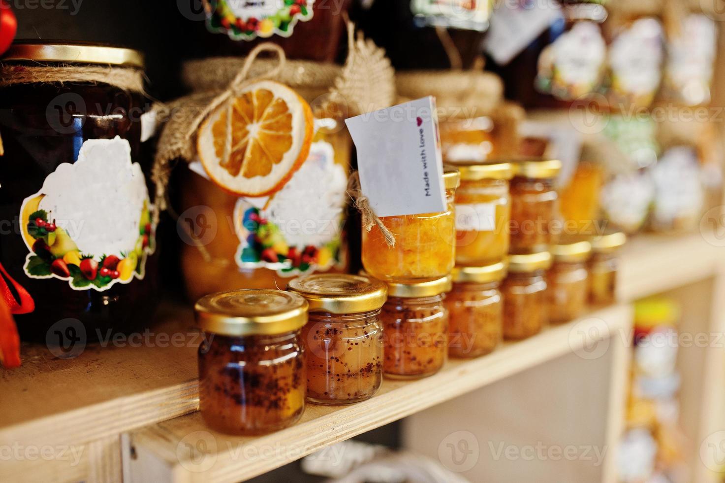Glass jars with different kinds of jam and berries of a supermarket shelves or grocery store. Homemade canning products. Made with love. photo