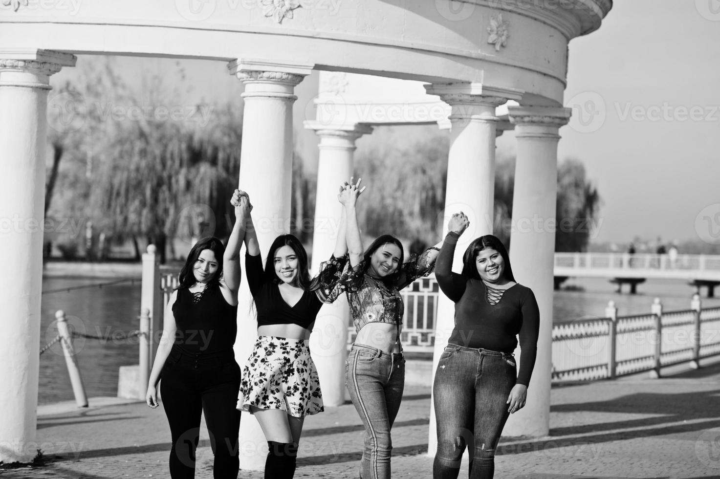 Group of four happy and pretty latino girls from Ecuador posed at street. photo