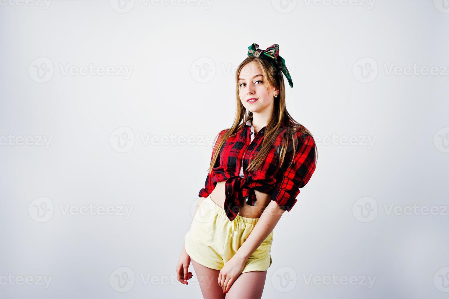 Young funny housewife in checkered shirt and yellow shorts pin up style isolated on white background. photo