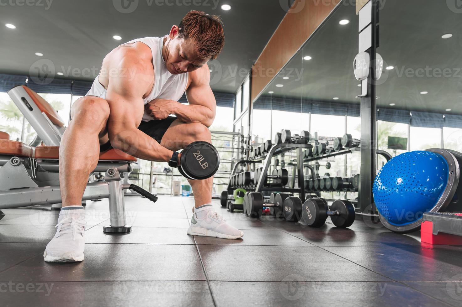 Asian men exercise by lifting weights or lifting dumbbells. Asian bodybuilder fitness concept photo