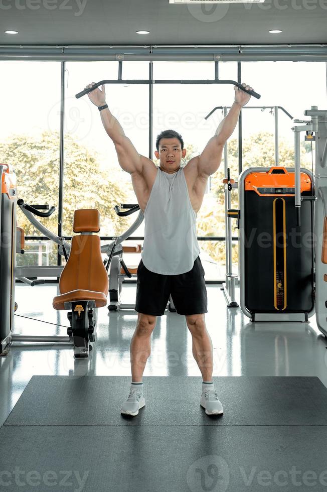 Asian men exercise by lifting weights or lifting dumbbells. Asian bodybuilder fitness concept photo