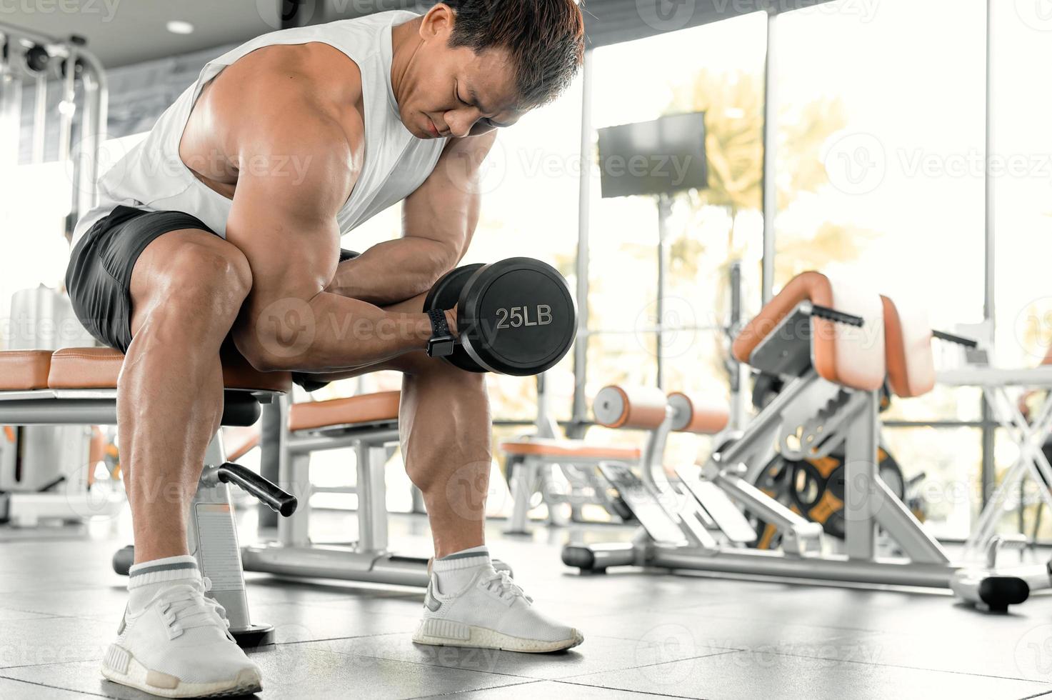 Asian men exercise by lifting weights or lifting dumbbells. Asian bodybuilder fitness concept photo