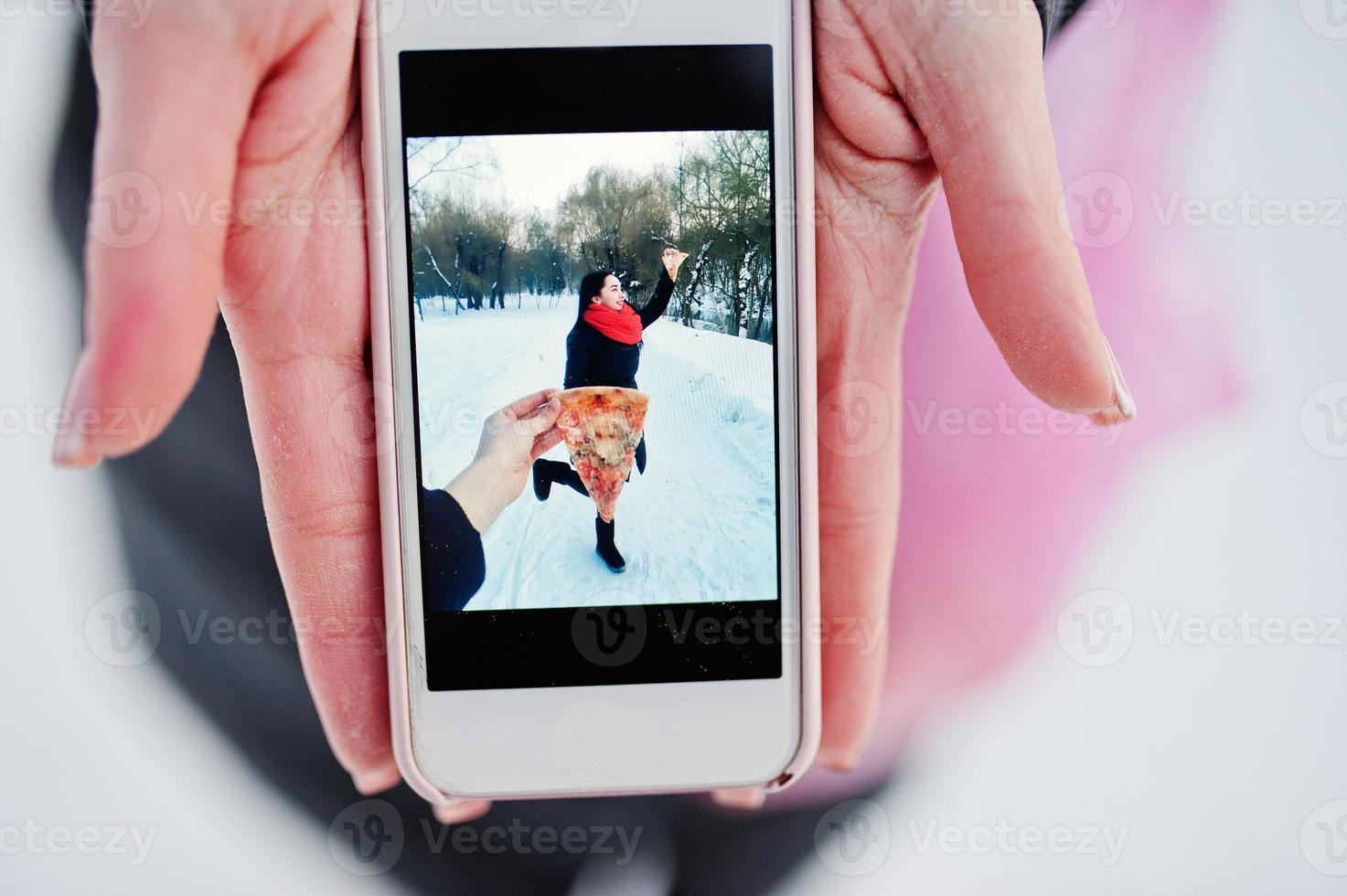 Girl in screen of phone with pizza. Funny concept. photo