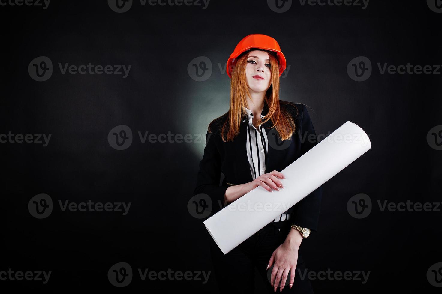 Engineer woman in orange protect helmet with construction paper projekt. photo