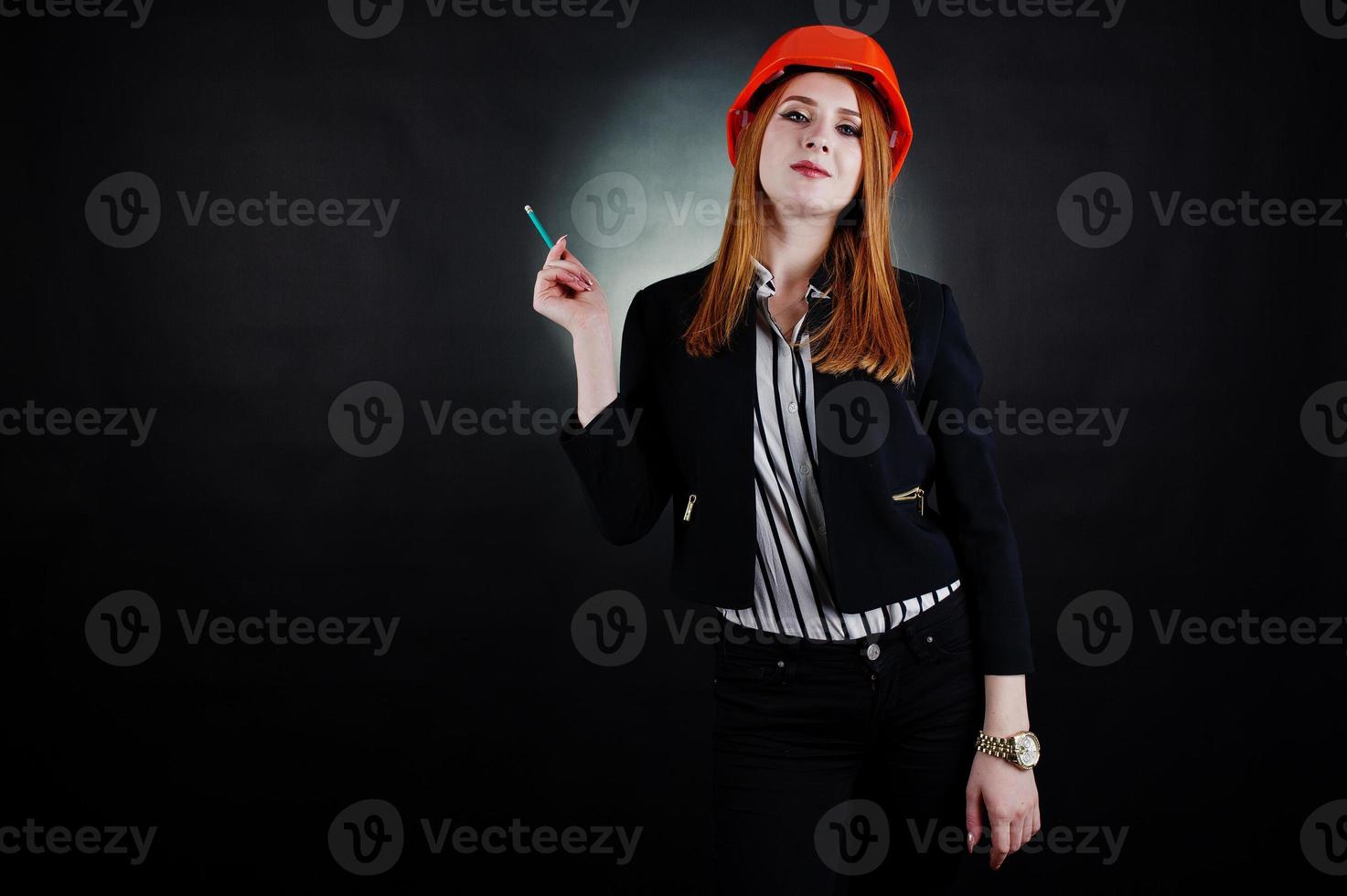 Engineer woman in orange protect helmet with pensil. photo