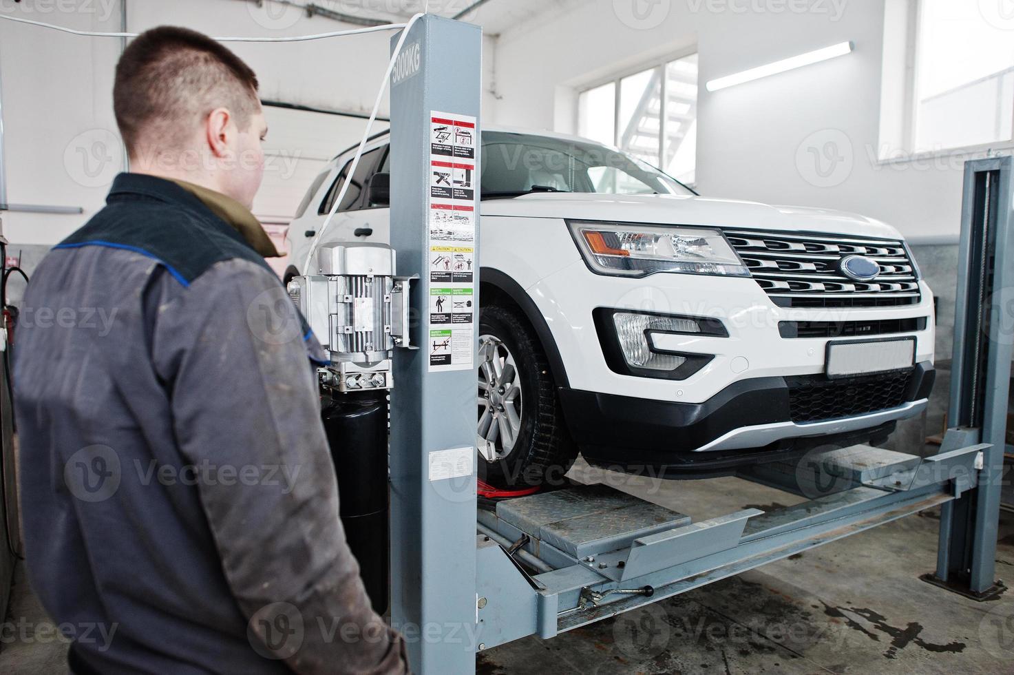 El mecánico de automóviles establece un automóvil suv americano para el diagnóstico y la verificación de la inclinación de la configuración en el taller de la estación de servicio. foto