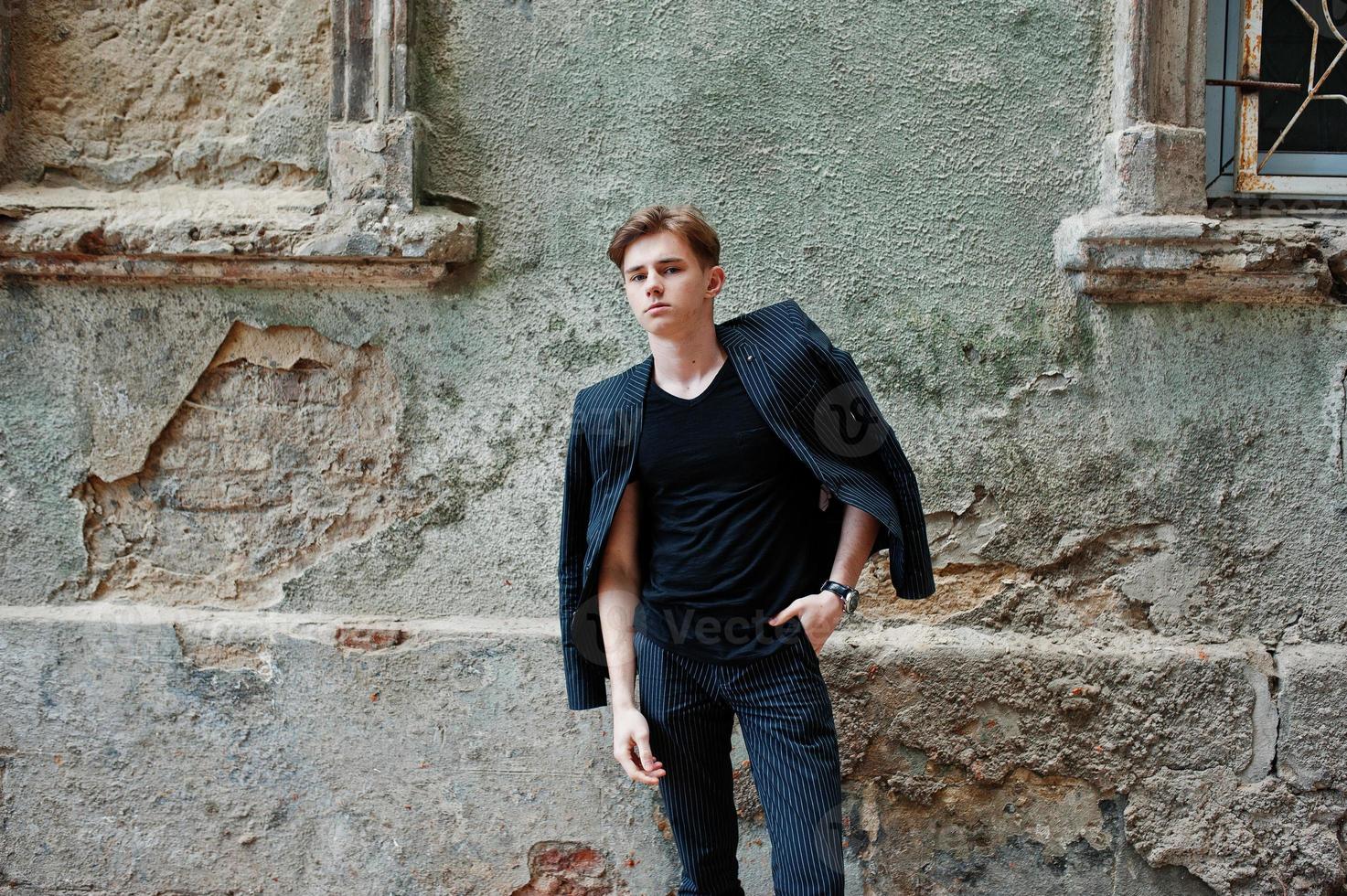 Young stylish macho boy in black jacket posed outdoor of street. Amazing model man. photo