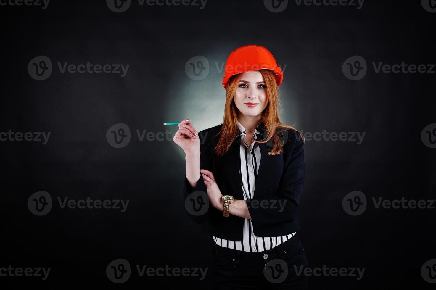 Engineer woman in orange protect helmet with pensil. photo