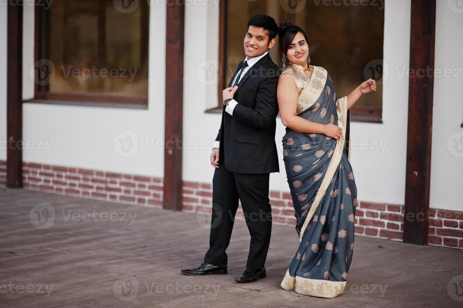 Elegant and fashionable indian friends couple of woman in saree and man in suit. photo