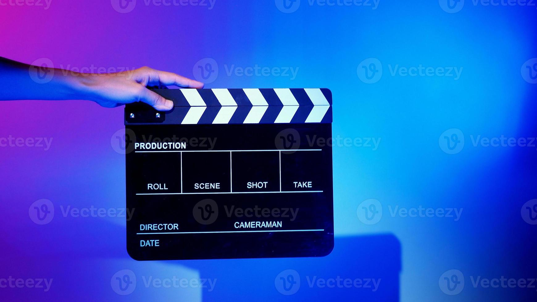 Crew hand holding plastic and wooden film slate board against camera. photo