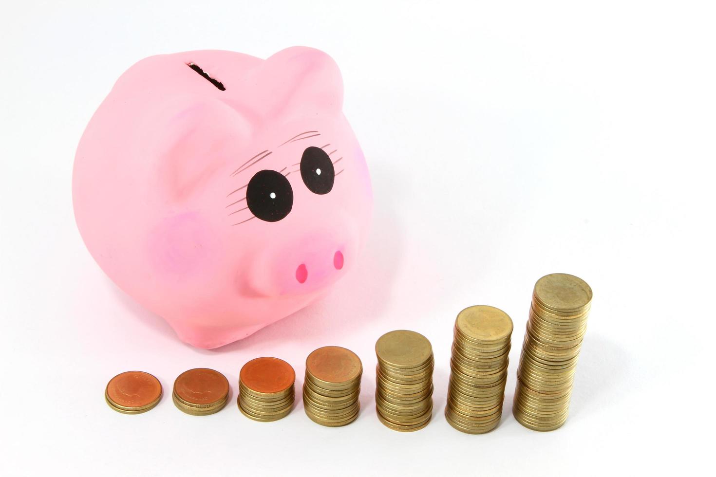 Piggy bank and coins isolated on white photo
