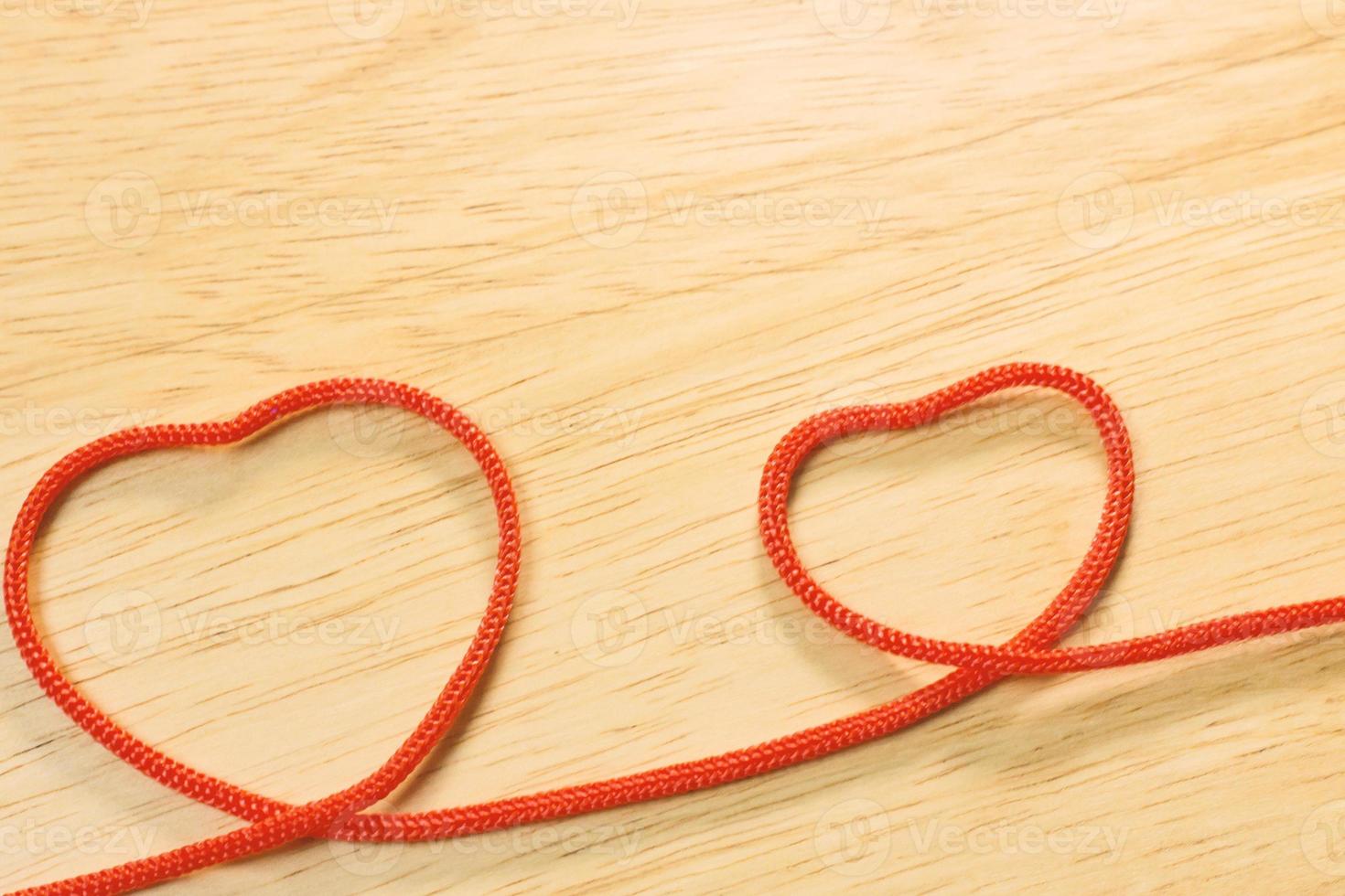 Red rope heart on wood plate valentine content. photo
