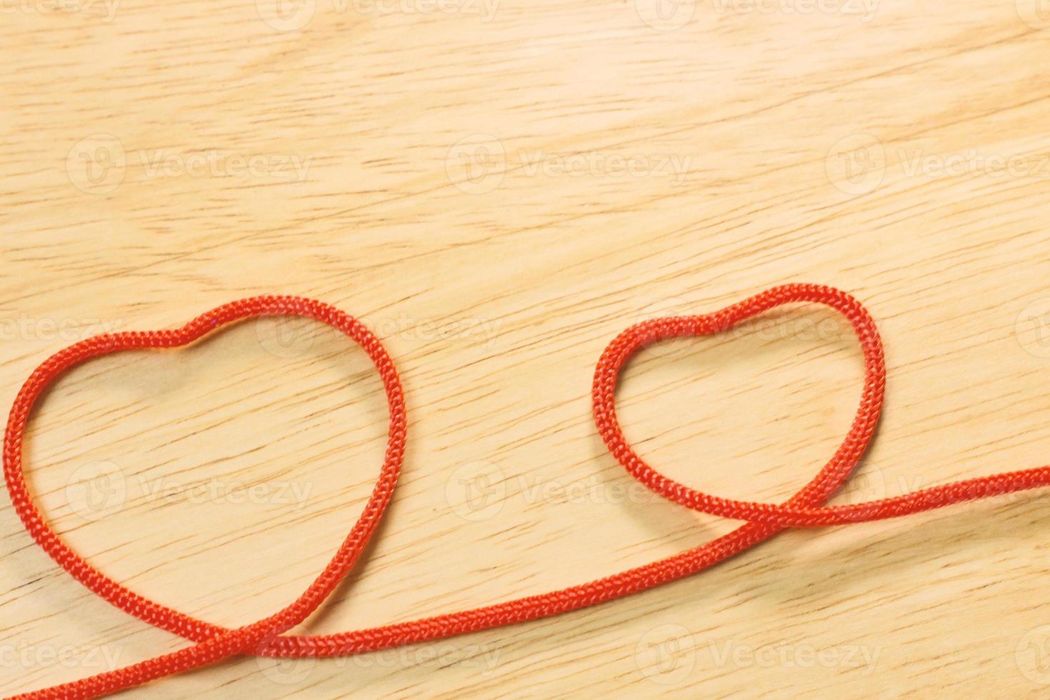 corazón de cuerda roja en placa de madera contenido de san valentín. foto