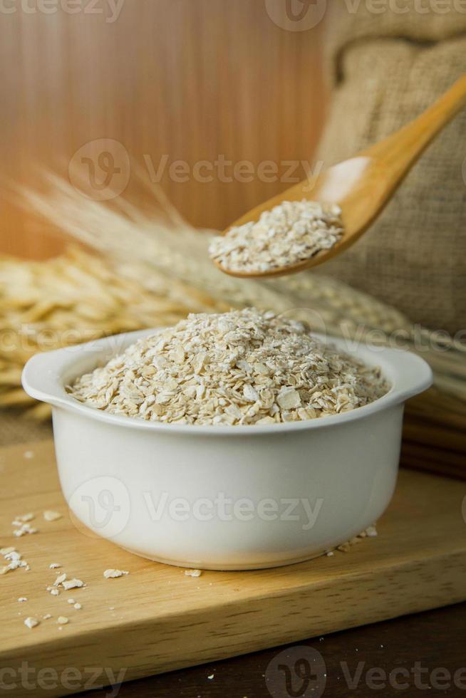 The Healthy breakfast cereal oat flakes in bowl on wooden table. photo