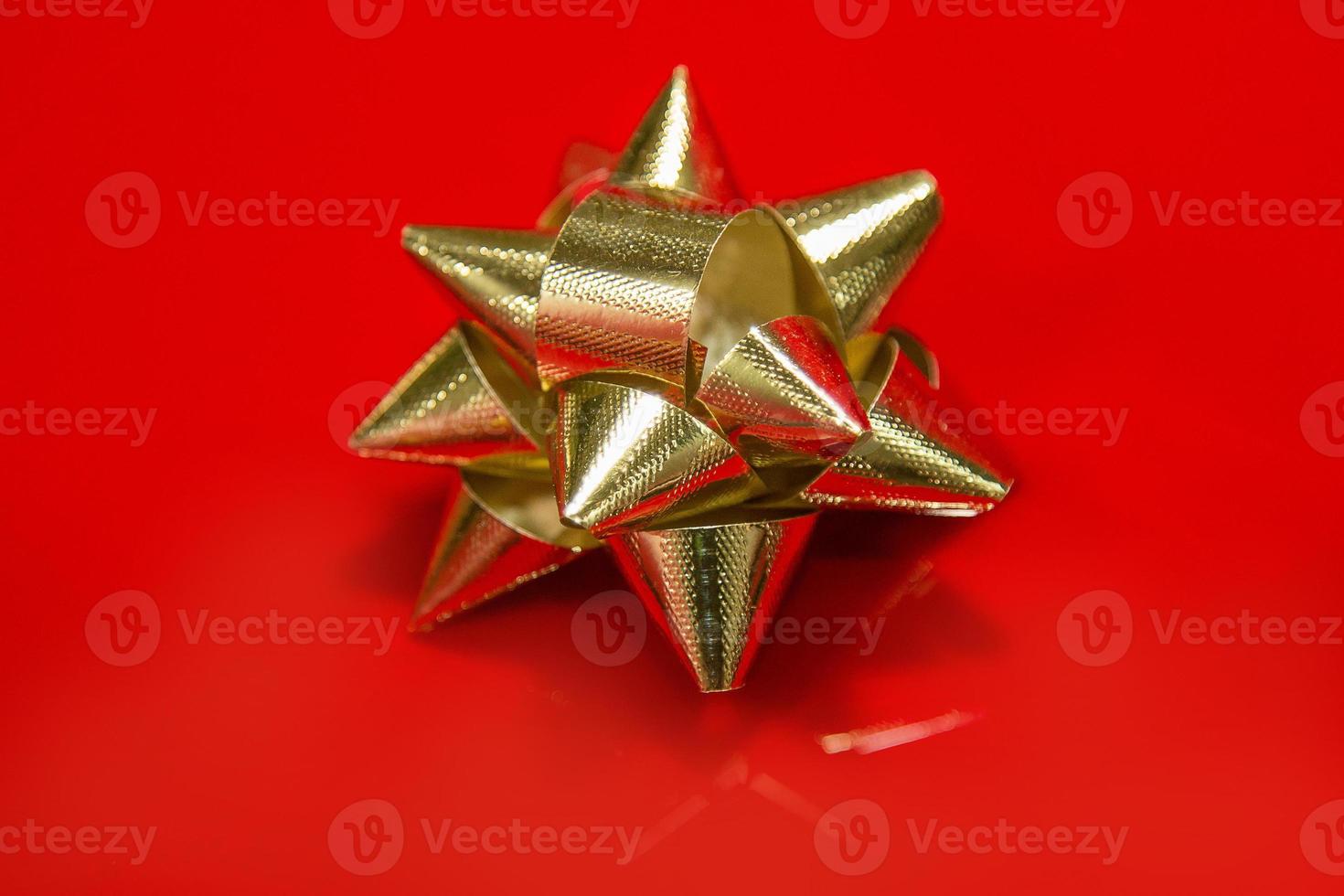Shiny gold satin ribbon on red background. photo