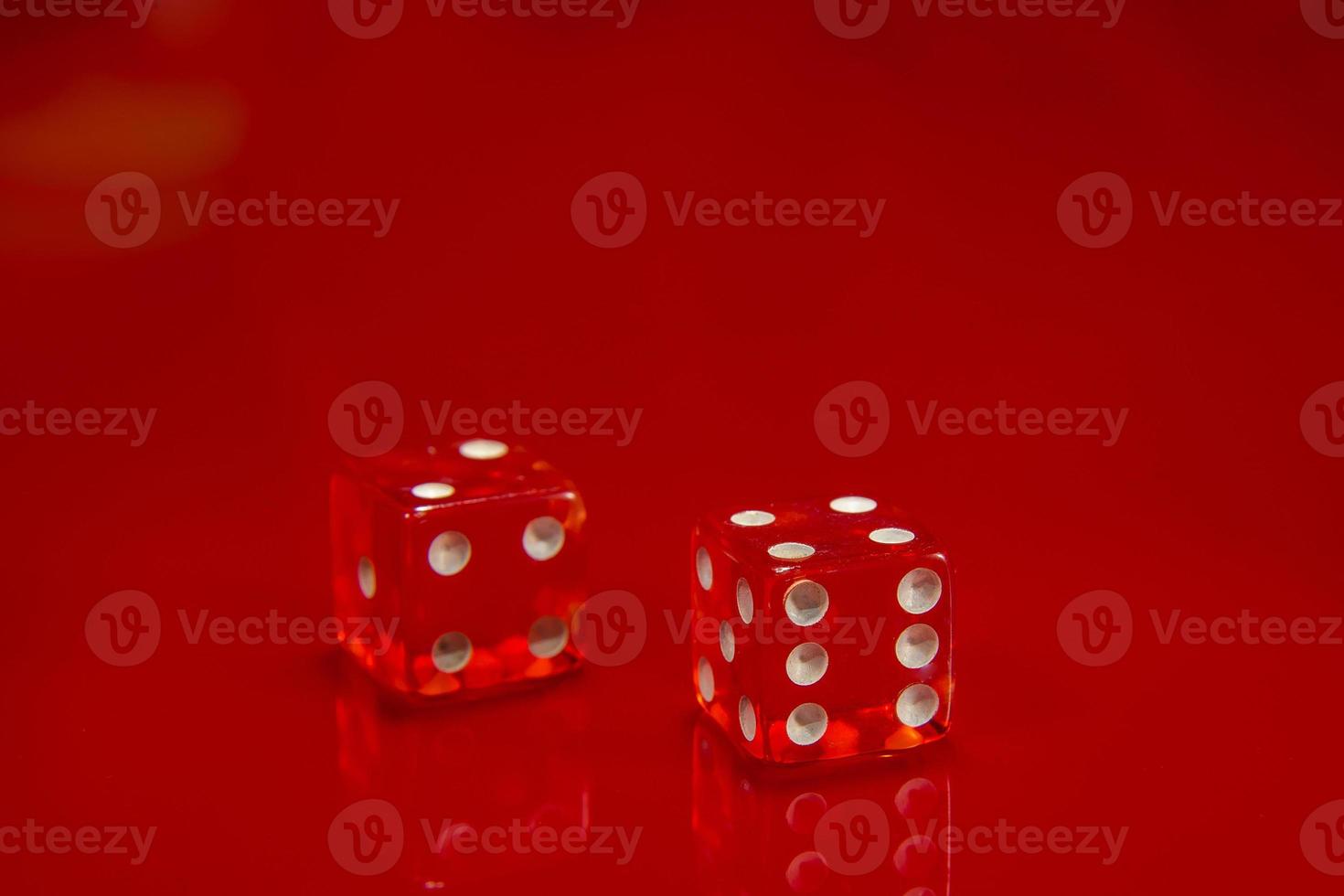 Two Red dice on bright red glossy background. photo