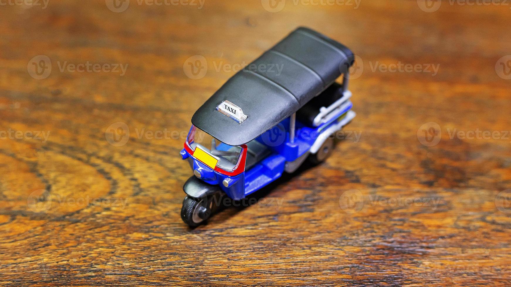 tuk tuk taxi  toy  on wood table close up image. photo