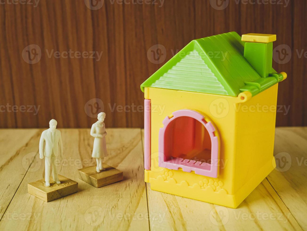 home toy  and white human figure on wood table for property, building content. photo