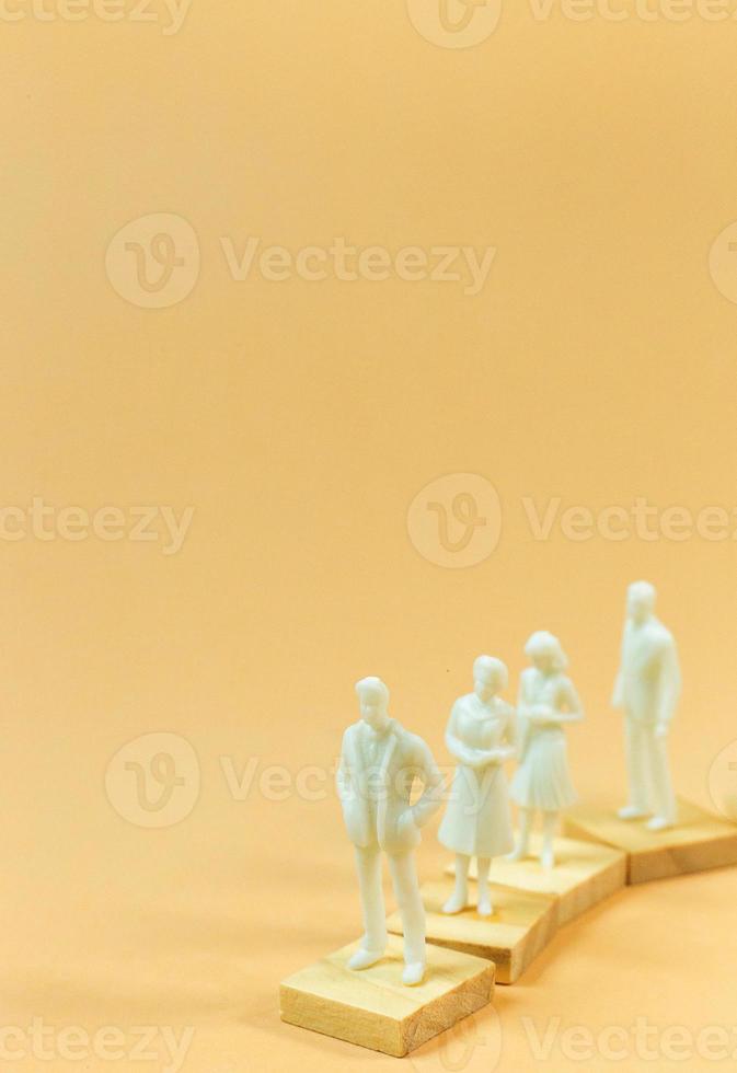 white  figure miniature on orange pastel for business content. photo