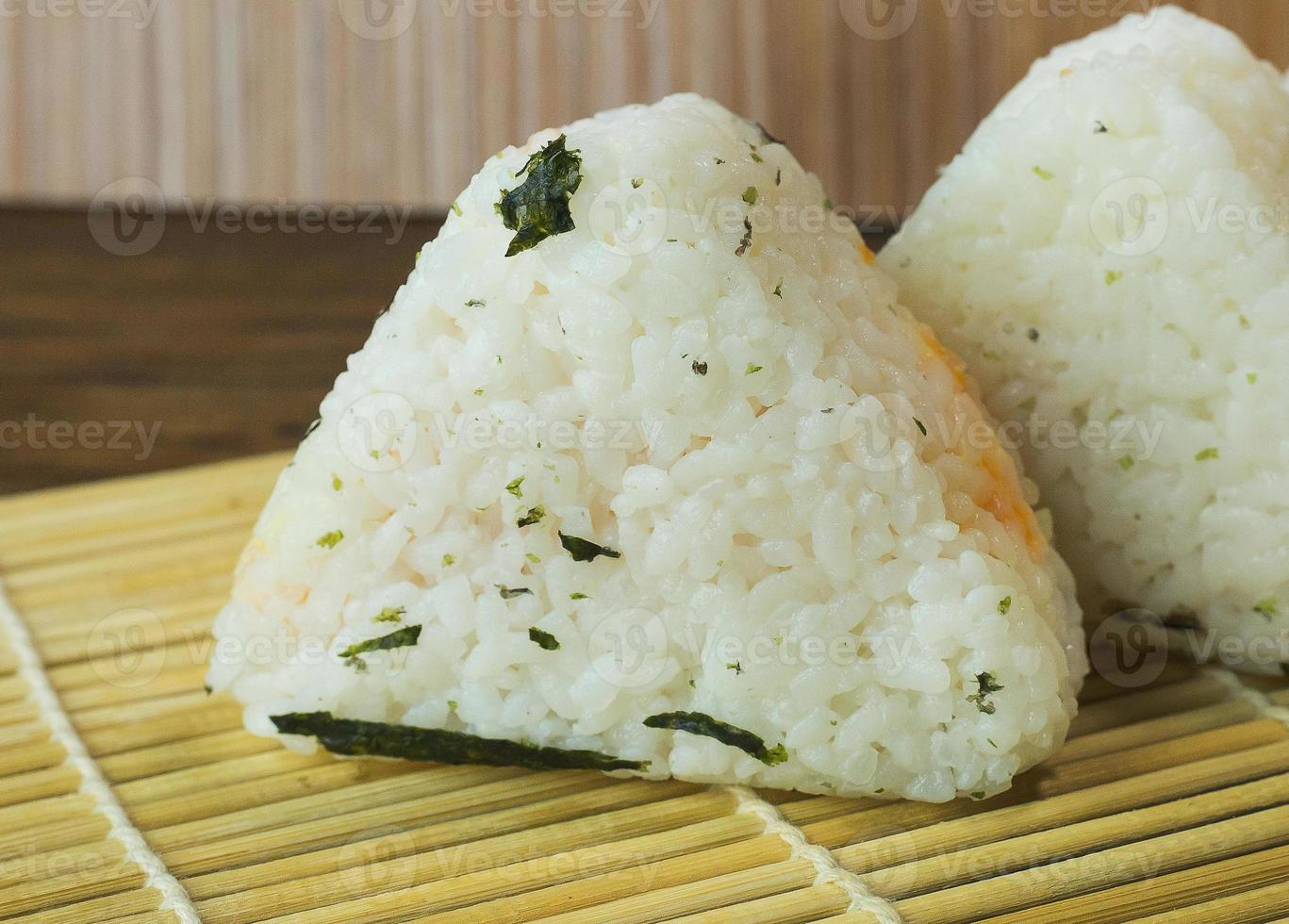 The Japanese food Onigiri  white rice formed into triangular or cylindrical shapes and often wrapped in nori. photo