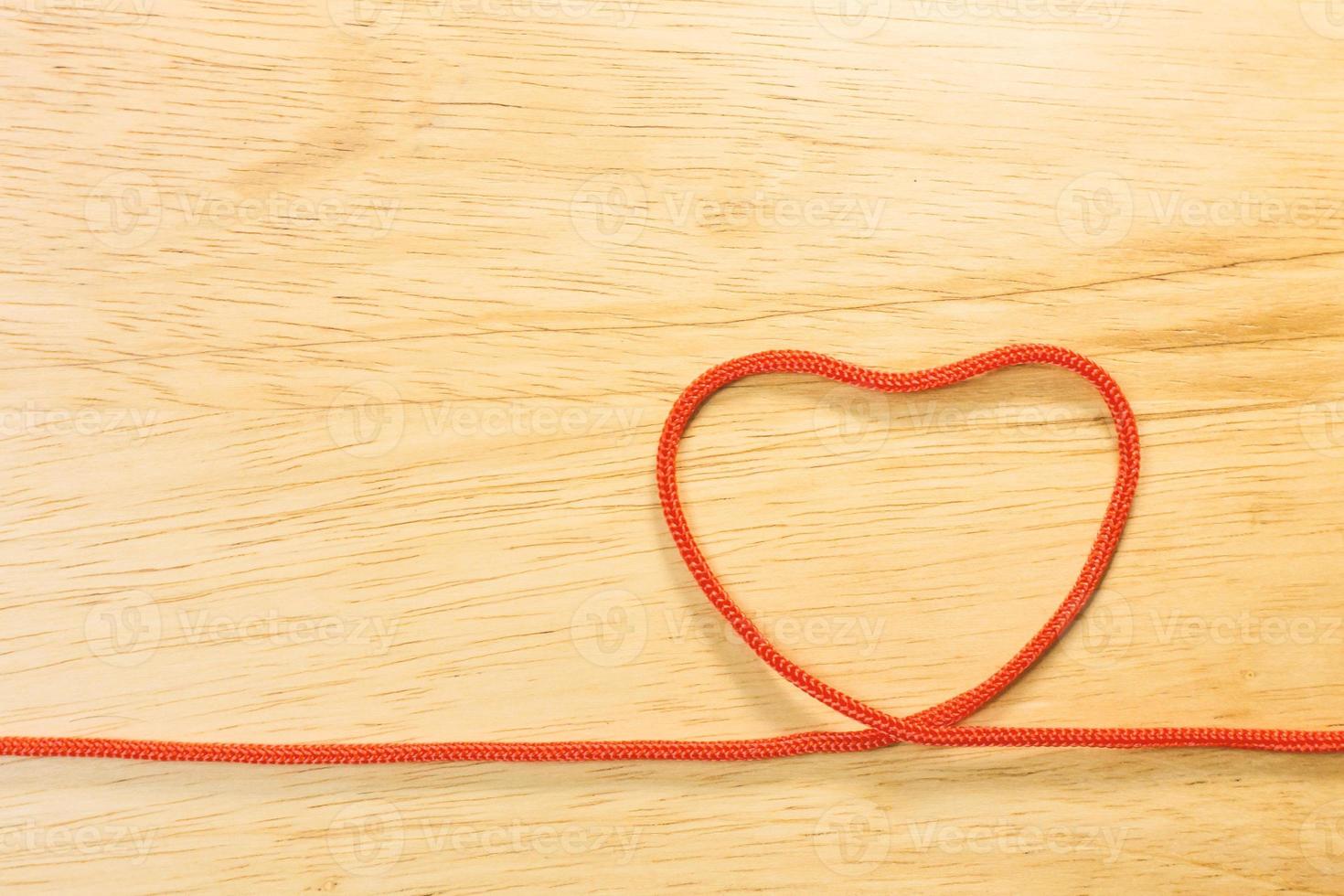 Red rope heart on wood plate valentine content. photo