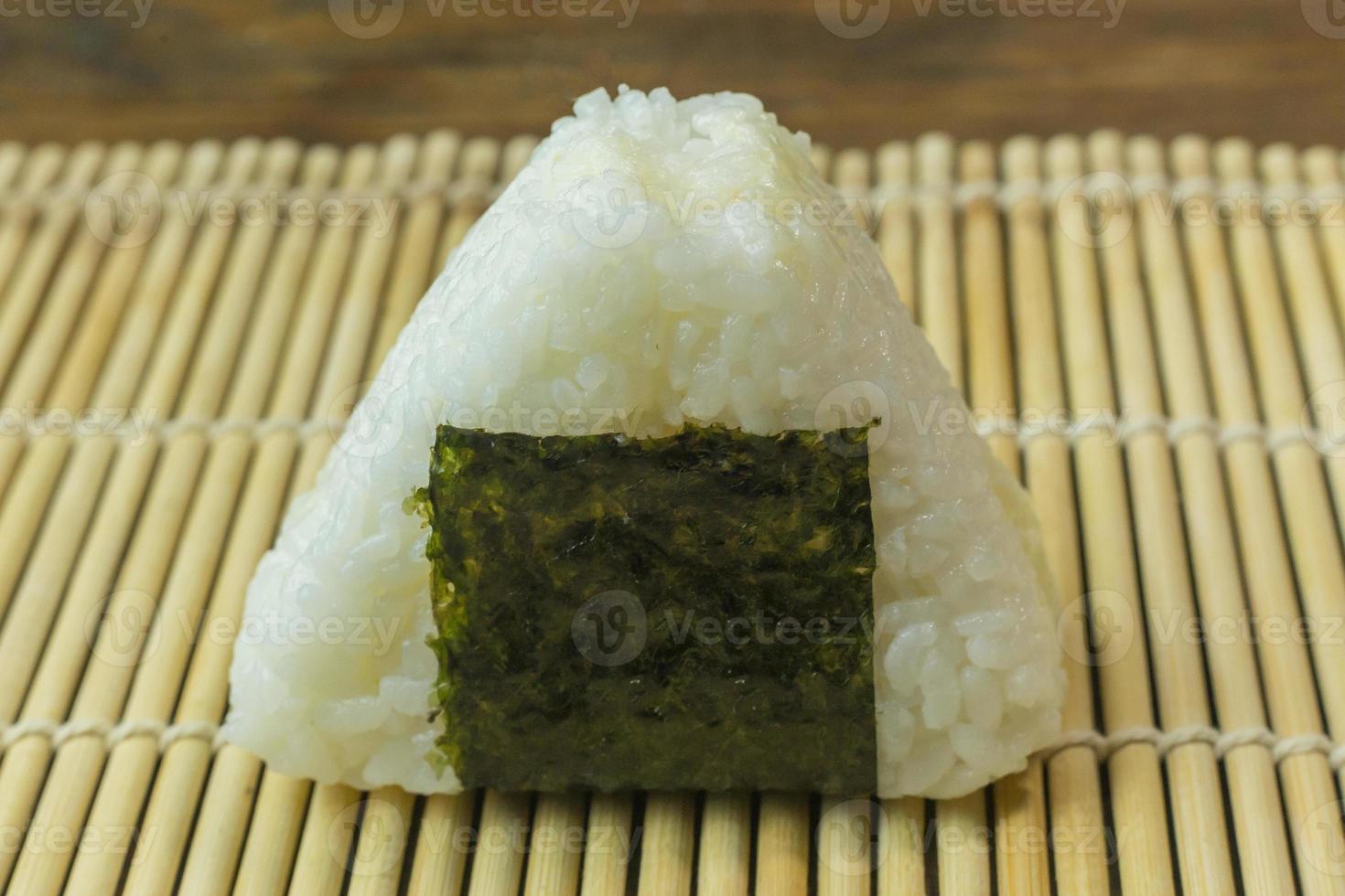 The Japanese food Onigiri  white rice formed into triangular or cylindrical shapes and often wrapped in nori. photo